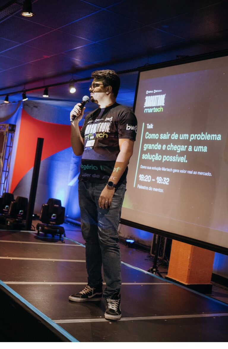 Rogério palestrando no Hackathon Martech, microfone em mãos